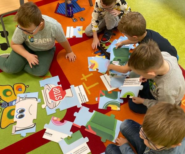 Dzieci układające puzzle na zajęciach edukacyjnych.